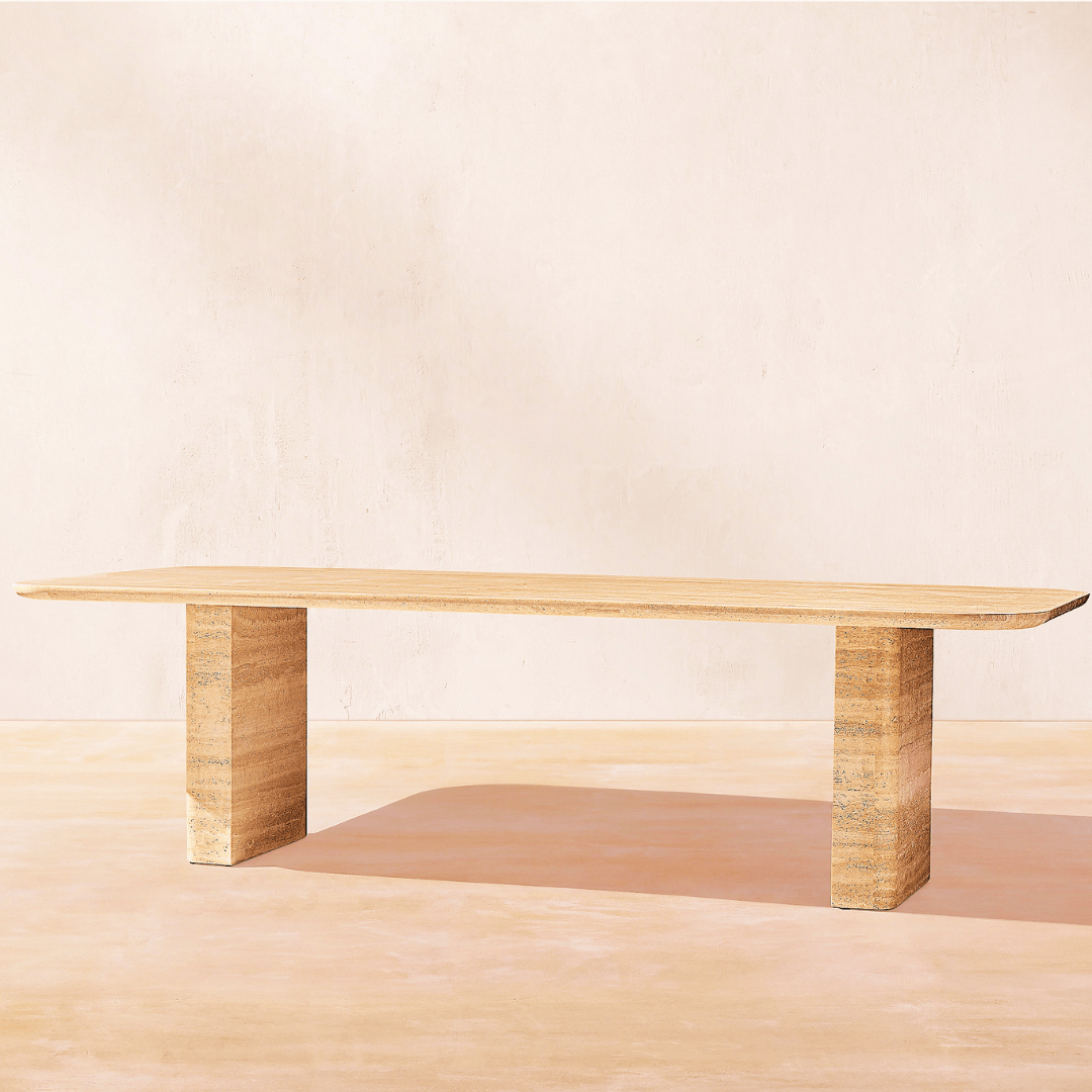 A minimalist wooden bench with clean lines sits against a pale, textured wall, embodying modern design. Its flat top and thick rectangular legs subtly shadow the light floor, echoing Travertables elegance found in The Majestic Travertine Dining Table.