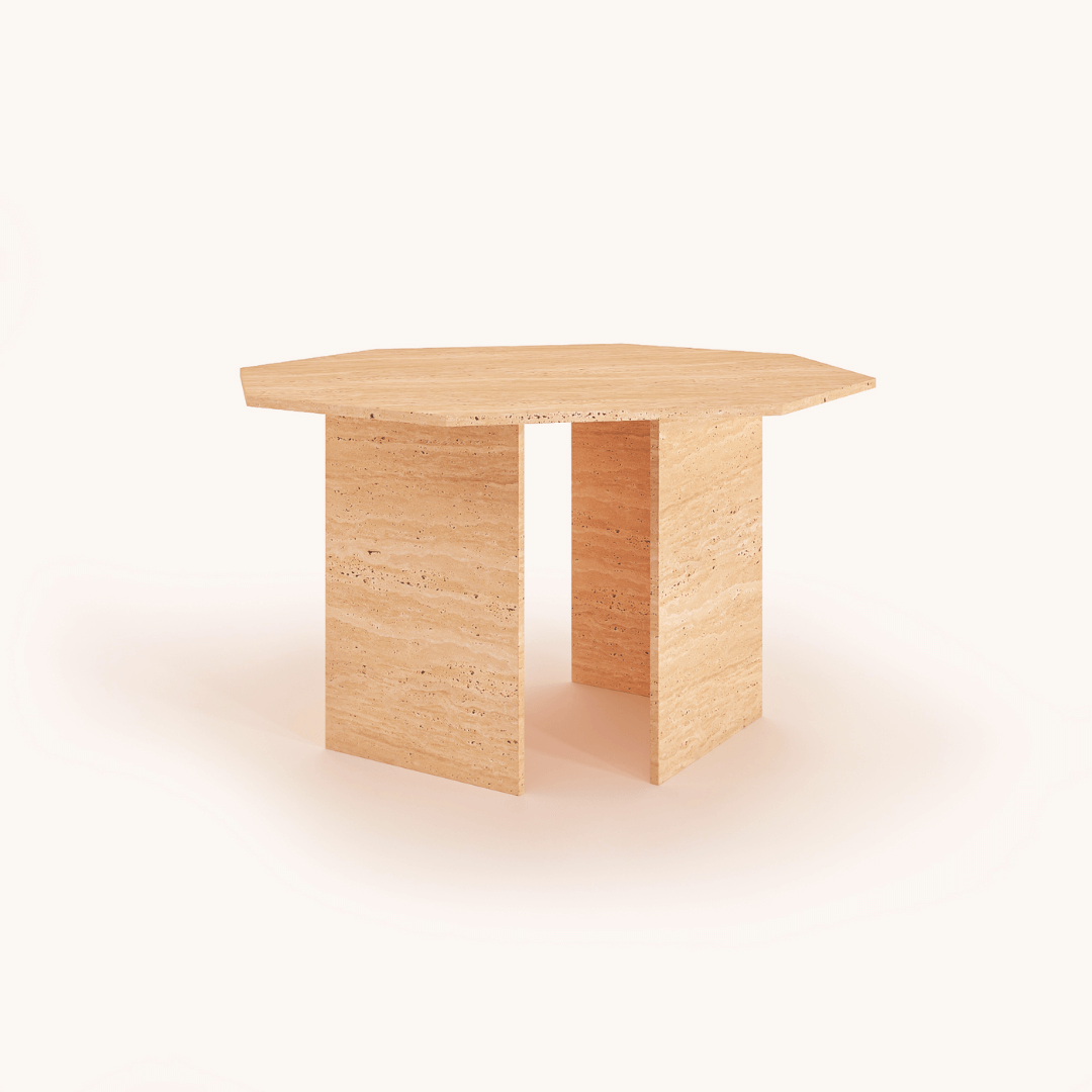 The Harmony Travertine Dining Table by Travertable is a hexagonal piece with a minimalist design, featuring a flat top and two vertical supporting panels made from textured stone. The off-white background enhances its contemporary style.