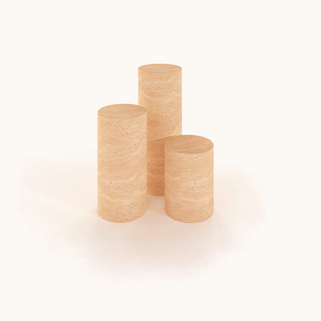 Three Travertable Travertine Pedestal side tables, each a beige cylindrical piece showcasing minimalist natural stone textures, are elegantly arranged in a triangular formation on a white background.