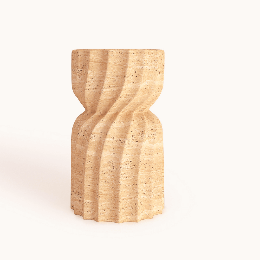 The Travertable Natural Beauty Travertine Stone Side Table boasts an hourglass design with a textured, wavy surface of horizontal grooves on a neutral background, creating a dynamic, flowing pattern to enhance your timeless space.