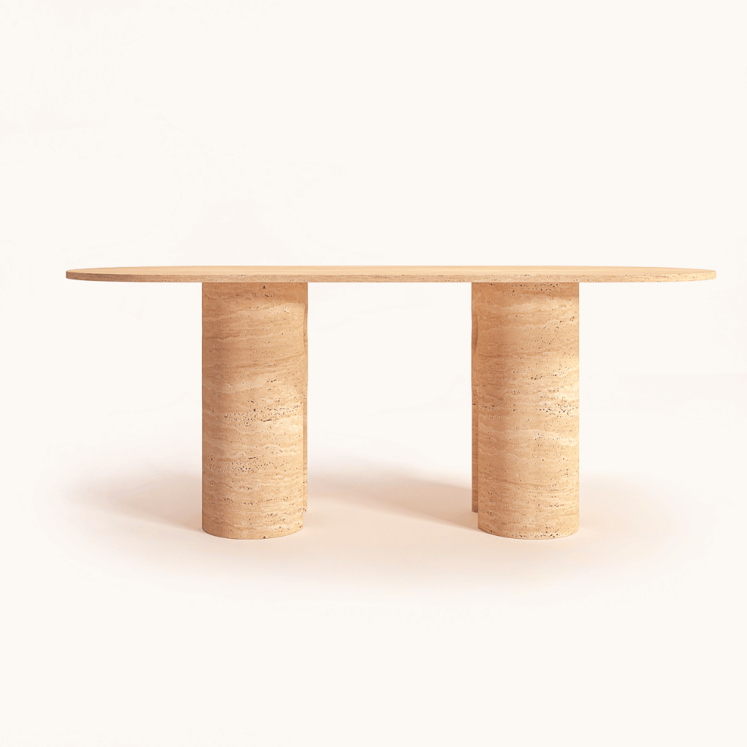 The Travertable Majesty Ellipse Table features an oval travertine surface and dual column legs, crafted from light beige stone or wood, with a natural textured finish, showcased against a plain white background.