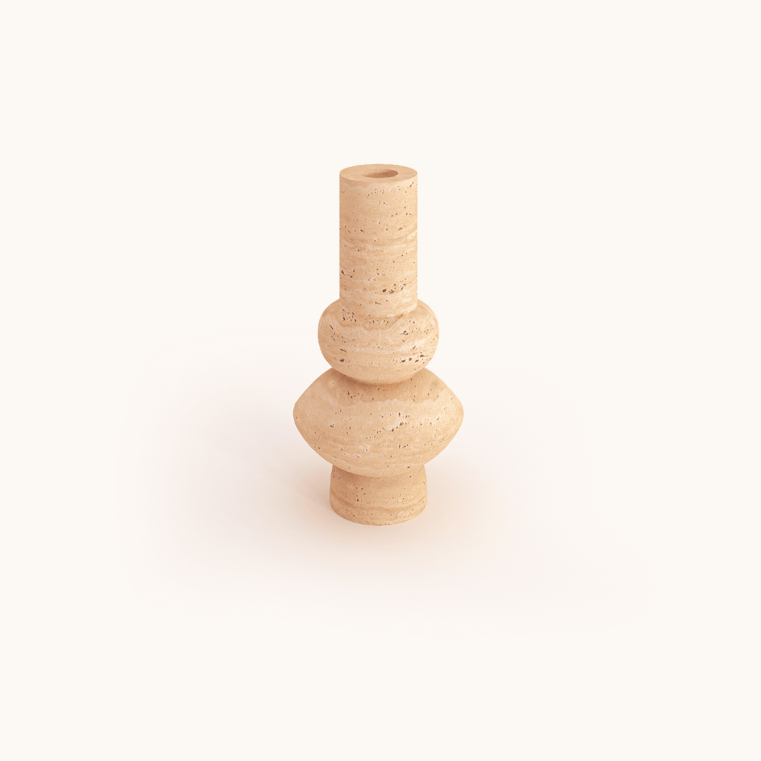 The Minimalist Beige Travertine Vase by Travertable features a light beige color, an abstract design with a tall, narrow neck, and an angular geometric body of stacked, rounded shapes. It has a textured, stone-like appearance.