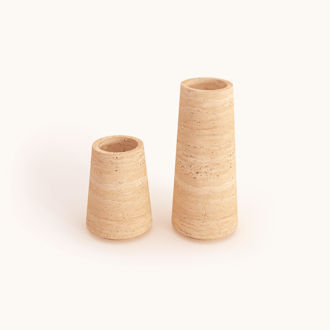 Two Classic Beige Travertine Vases by Travertable, set against a white background. The right vase is taller and cylindrical, while the left one is shorter and slightly wider. Both feature an earthy, natural finish with a tan, textured ceramic design.