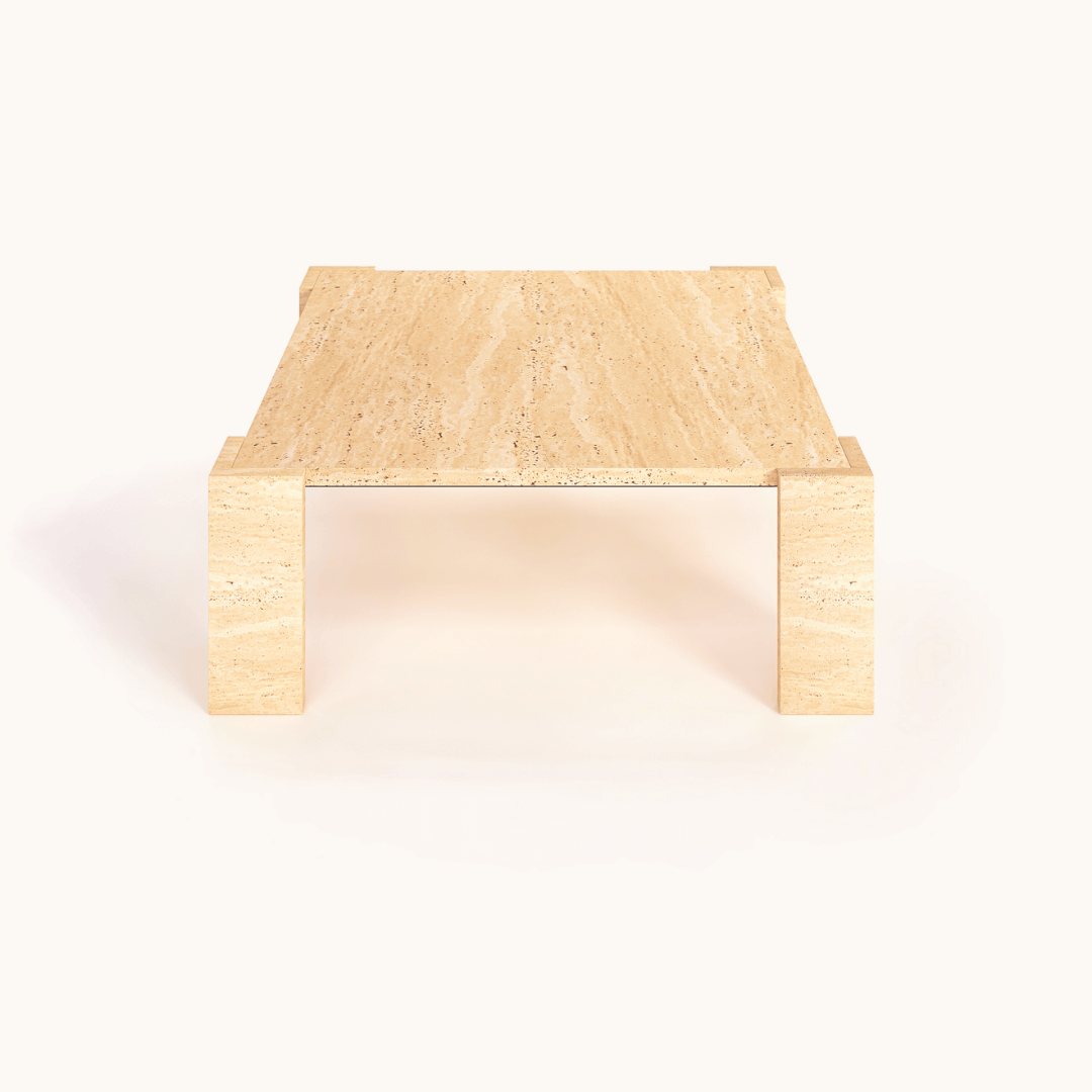 Travertine Coffee Table. This minimalist marvel, perfectly balanced between raw texture and refined form, features light travertine stone with smooth surfaces supported by block-style legs against a simple white background.