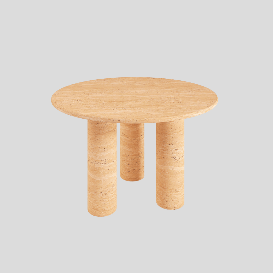 The Trio Round Travertine Dining Table by Travertable features a smooth travertine top and three cylindrical legs, set against a plain light gray background.