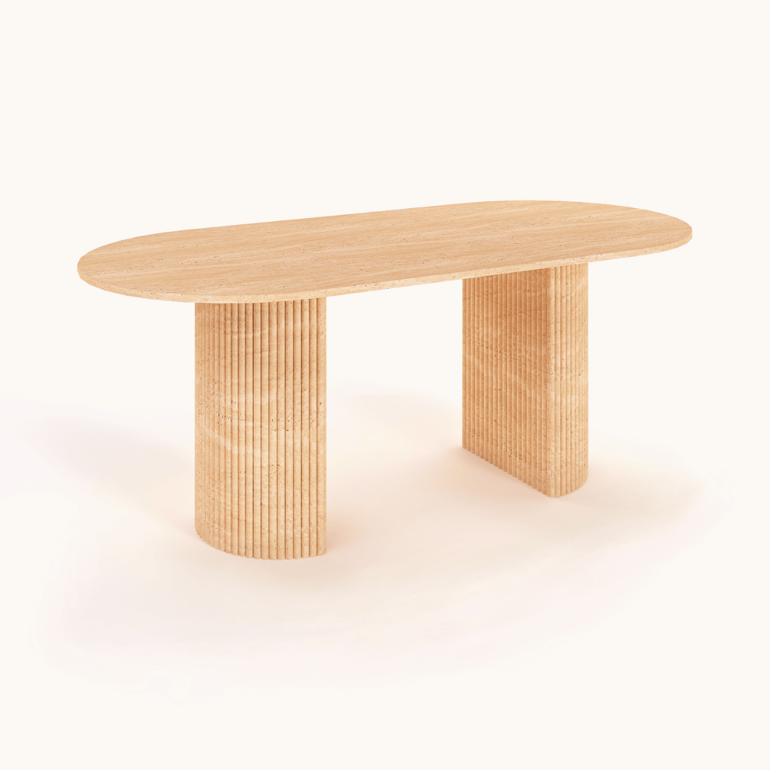 The Regal Ellipse Travertine Dining Table by Travertable exudes modern sophistication with its smooth oval top and two ribbed cylindrical legs, enhanced by a light, natural finish that adds minimalist elegance against a plain white backdrop.