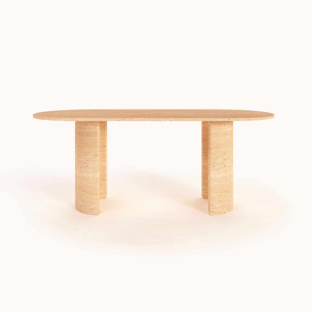 The Regal Ellipse Travertine Dining Table by Travertable is an elegant minimalist piece with an oval shape, smooth surface, and two cylindrical legs. Its light, natural finish enhances the simple design and modern sophistication against a plain white backdrop.