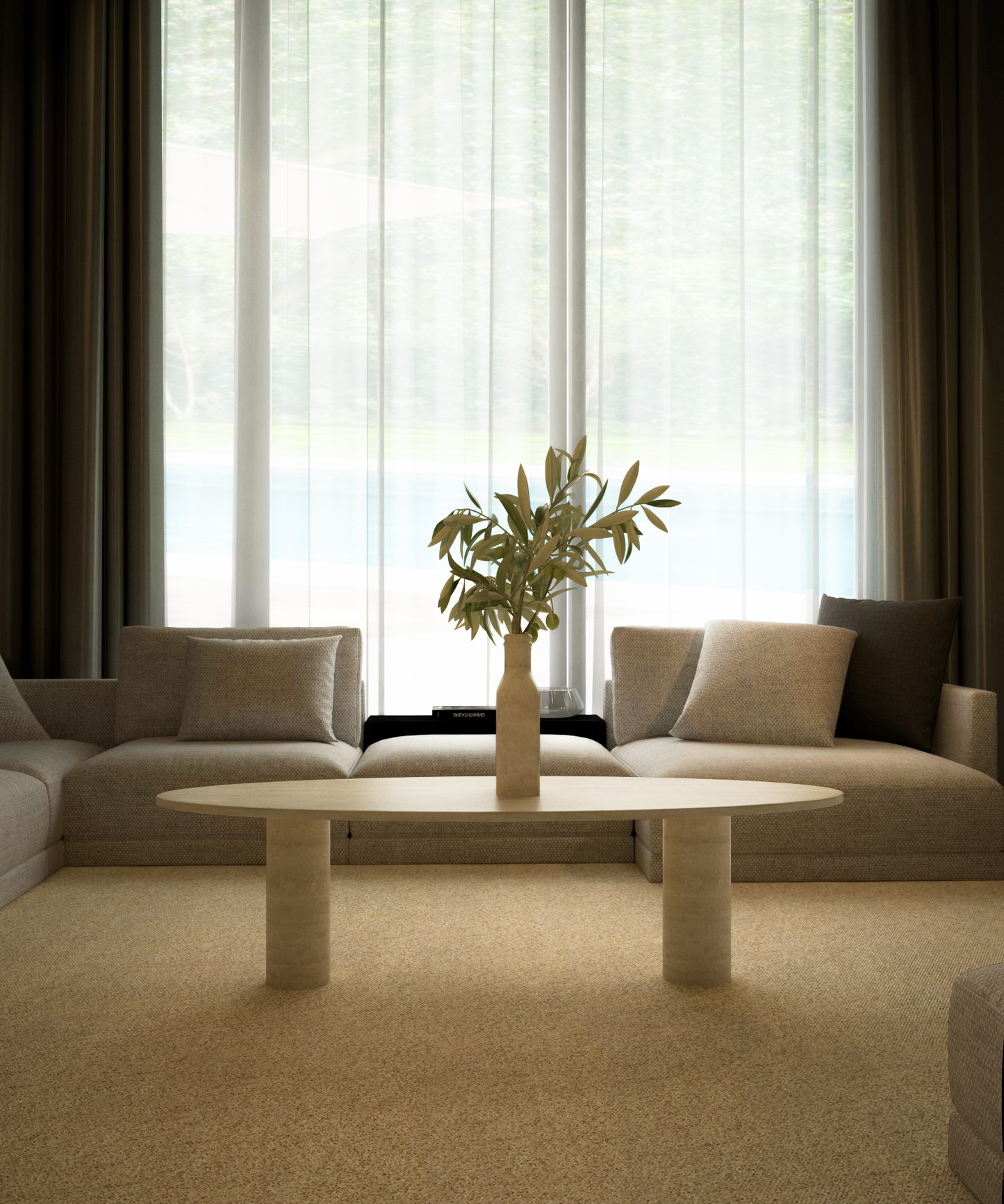 A minimalist living room features two beige sofas, TRAVERTABLEs Ellipse Travertine Coffee Table with a solid cylindrical base, a vase of greenery, and large windows with sheer curtains letting in natural light.