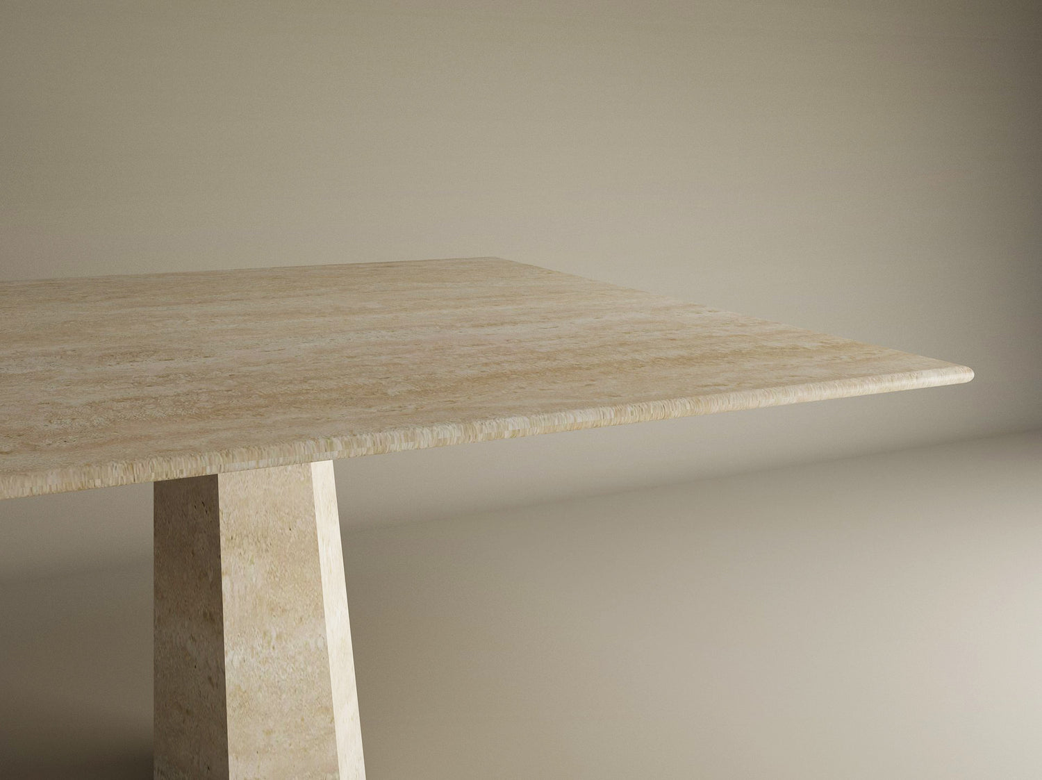 A close-up of the Square Travertine Dining Table by TRAVERTABLE shows its smooth, light beige travertine top and thick Rockcone center base, highlighting the tables minimalist design against a plain background.