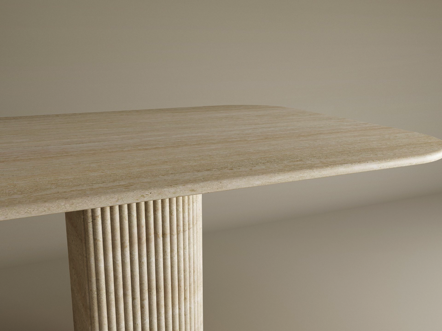 The TRAVERTABLE Rectangular Travertine Dining Table showcases a fluted round solid stone base and smooth tabletop, blending minimalist elegance and heirloom quality in a customizable design against a neutral backdrop.