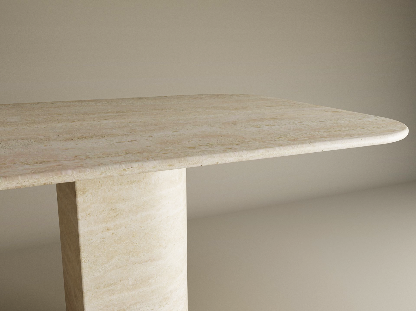 The TRAVERTABLE Rectangular Travertine Dining Table features a natural stone top with rounded corners and a thick sloped pedestal base, all crafted from solid travertine, standing out against a plain neutral background. Customization available.