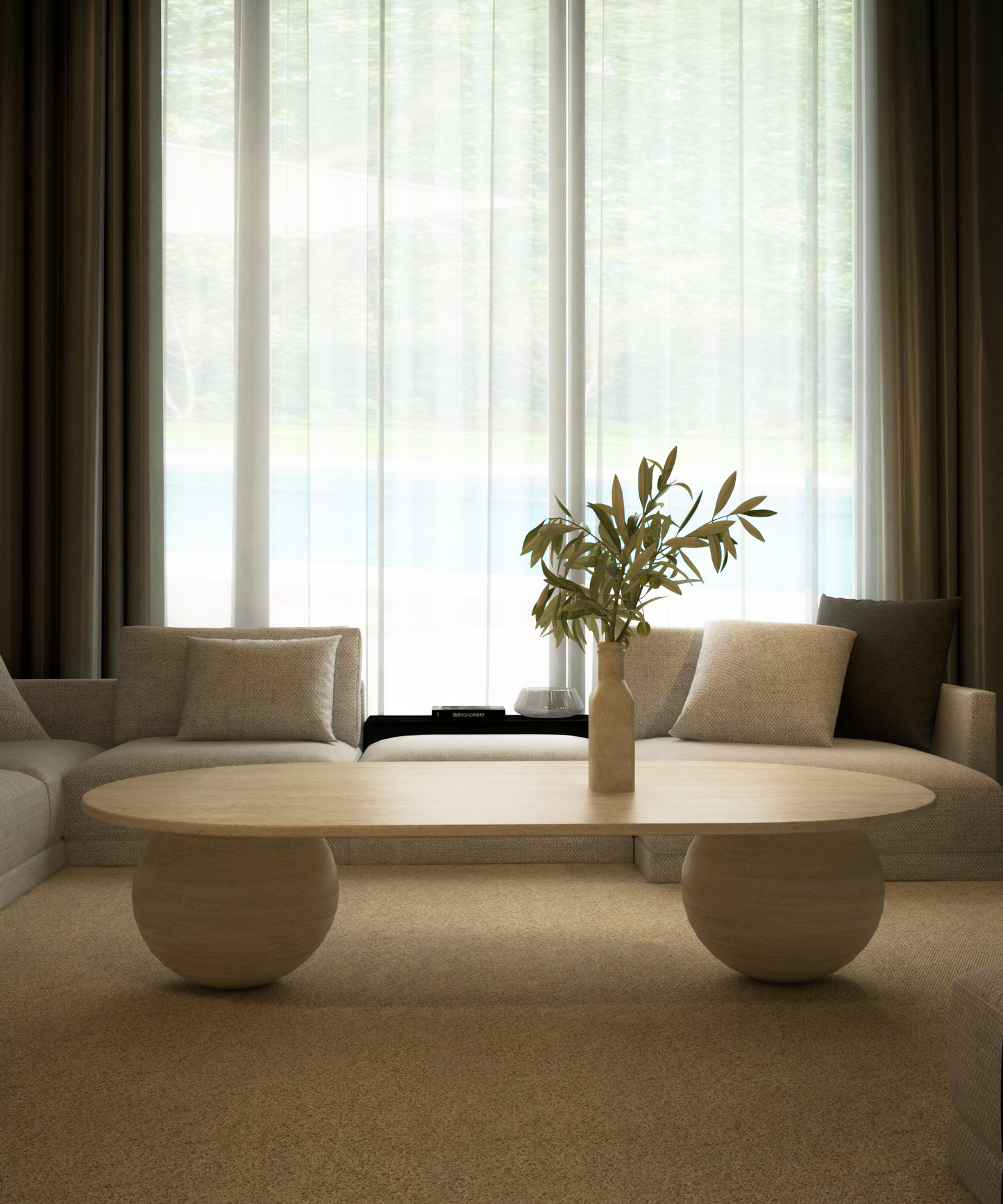A modern living room with beige sofas and a TRAVERTABLE Oval Travertine Coffee Table with Stone Ball Base – Artistic Travertine – Customizable. Sheer white curtains diffuse the light, while muted decor and a neutral rug create calm, minimal style.