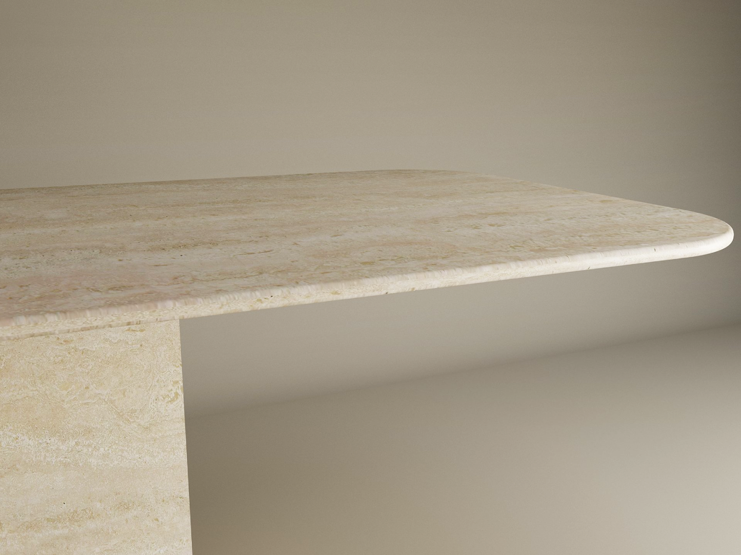 A close-up of the TRAVERTABLE Rectangular Travertine Dining Table with Block Base shows its thick natural stone top, rounded edges, and sturdy base, set against a plain background. Customizable design by TRAVERTABLE.