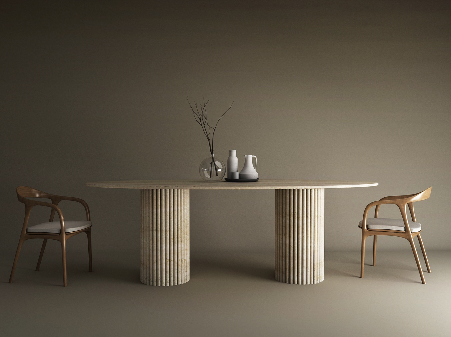 A minimalist dining setup with the TRAVERTABLE Ellips Travertine Dining Table featuring a vertical groove organic stone base, two wooden chairs with white cushions, and vases with branches as a centerpiece on a neutral-toned background.