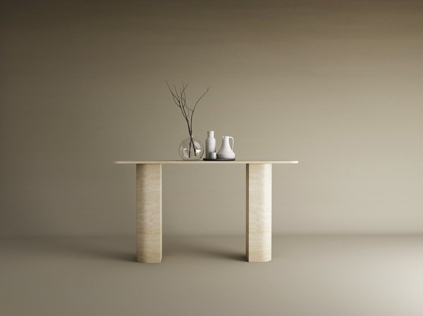 The TRAVERTABLE Rectangular Travertine Console Table with Sloped Pedestal Base in natural stone displays a glass vase with bare branches and two ceramic pitchers, set against a plain beige background.