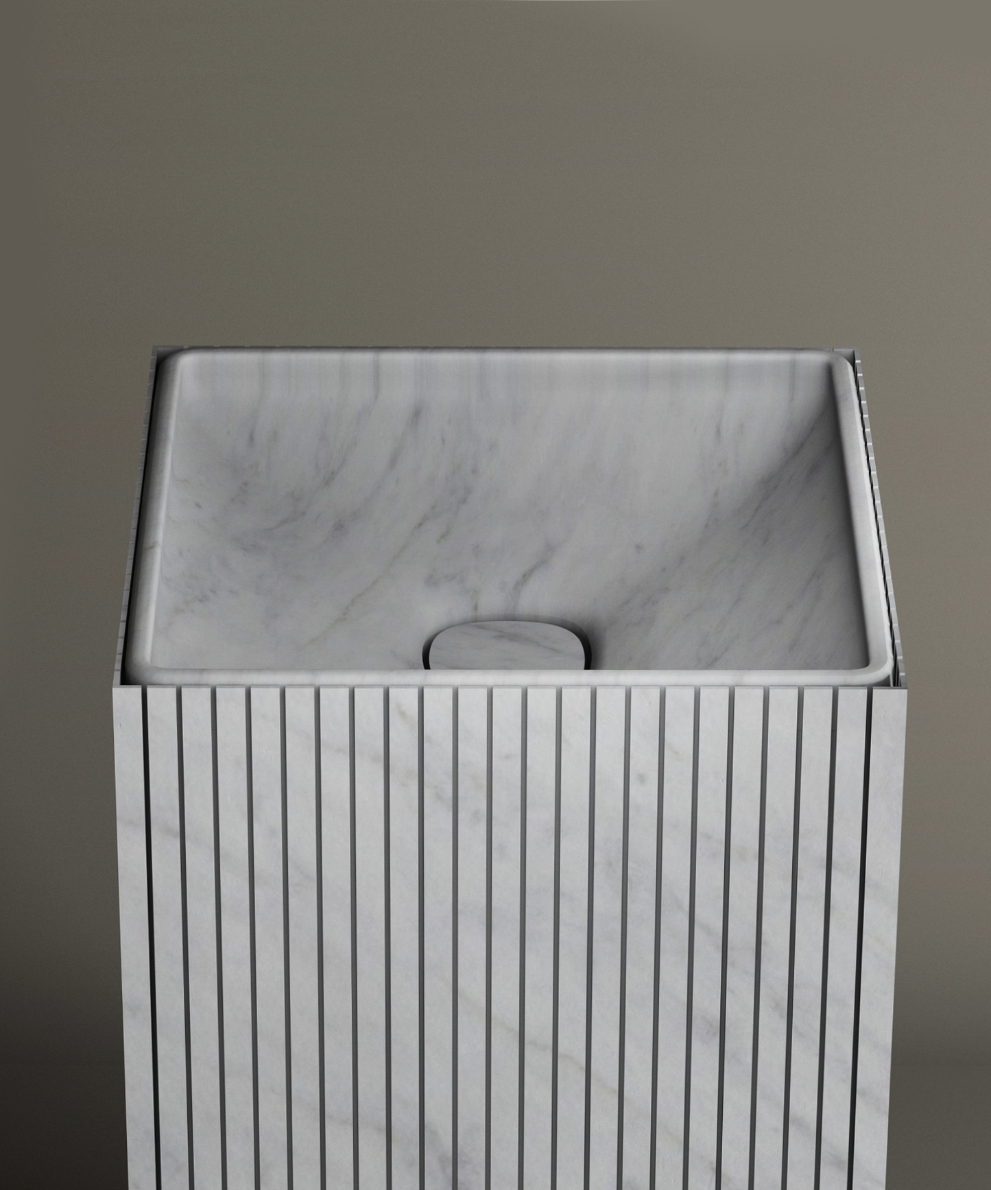 The TRAVERTABLE Carrara Square Fluted Marble Pedestal Vanity Sink features vertical grooves, a smooth angled basin, and a minimalist design—ideal for contemporary bathrooms with neutral backgrounds.