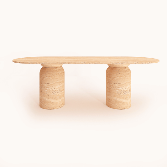 The Pillar Oval Travertine Dining Table by Travertable features a modern design with a long oval top and two cylindrical stone legs. Its natural beige hue and subtle leg textures exude elegance, displayed against a plain white background.