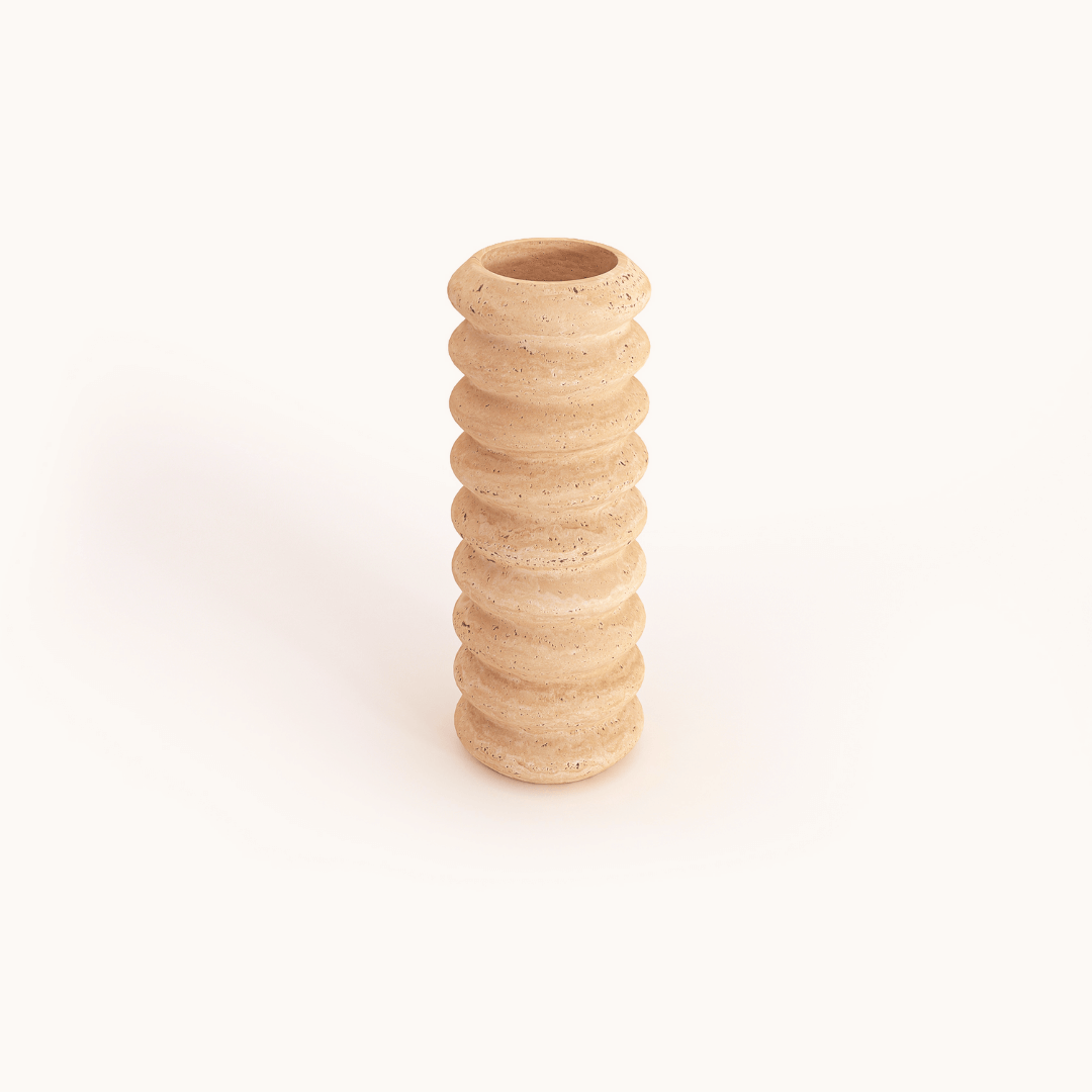 The Travertable Natural Beauty Oval Travertine Vase is tall and cylindrical, crafted from light, speckled material with a textured surface of stacked, rounded ridges, displayed against a plain white background.