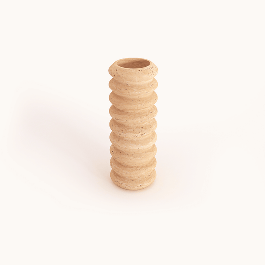 The Travertable Natural Beauty Oval Travertine Vase is tall and cylindrical, crafted from light, speckled material with a textured surface of stacked, rounded ridges, displayed against a plain white background.