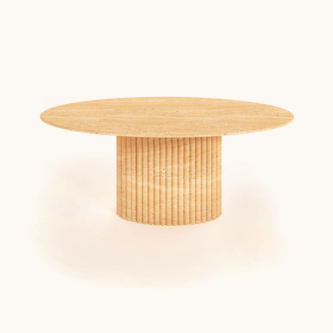 The Elysian Travertine Feast Table by Travertable features an elegant oval design and ribbed pedestal base, elegantly displayed against a plain white background. It offers customization options to match your unique style.