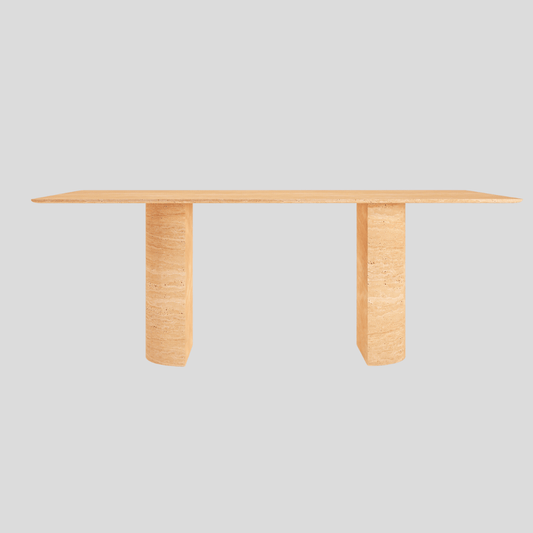 The Travertable Horizon Travertine Dining Table features a sleek rectangular wooden design with a light finish, its flat top supported by two thick legs contrasting against a plain gray background to emphasize its minimalistic elegance.