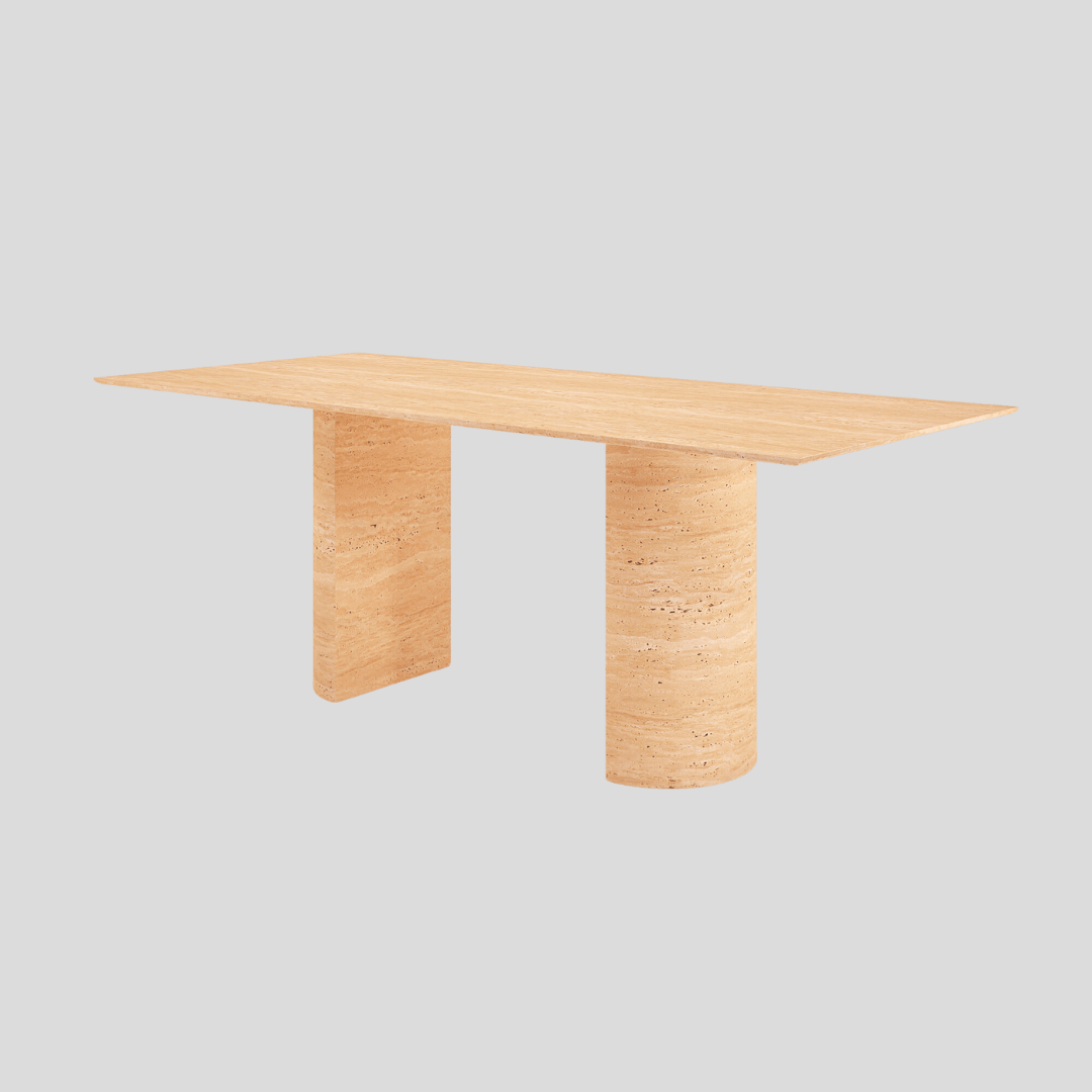 Amidst a plain gray backdrop, Travertable’s Horizon Travertine Dining Table showcases a minimalist aesthetic with its rectangular top and two robust cylindrical legs, radiating subtle elegance.