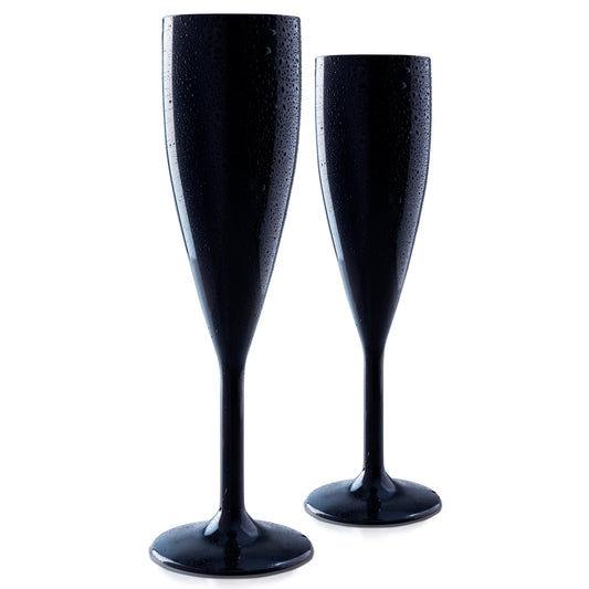 Against a white background, two Unbreakable Black Champagne Flutes by Mamaco Home, crafted from elegant polycarbonate and featuring crystal-clear clarity with droplets of condensation, stand upright.