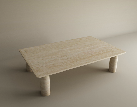 The TRAVERTABLE Rectangular Travertine Coffee Table features a smooth warm travertine stone top and four solid cylindrical bases, shown against a plain, light-colored background. Customizable to suit your needs.