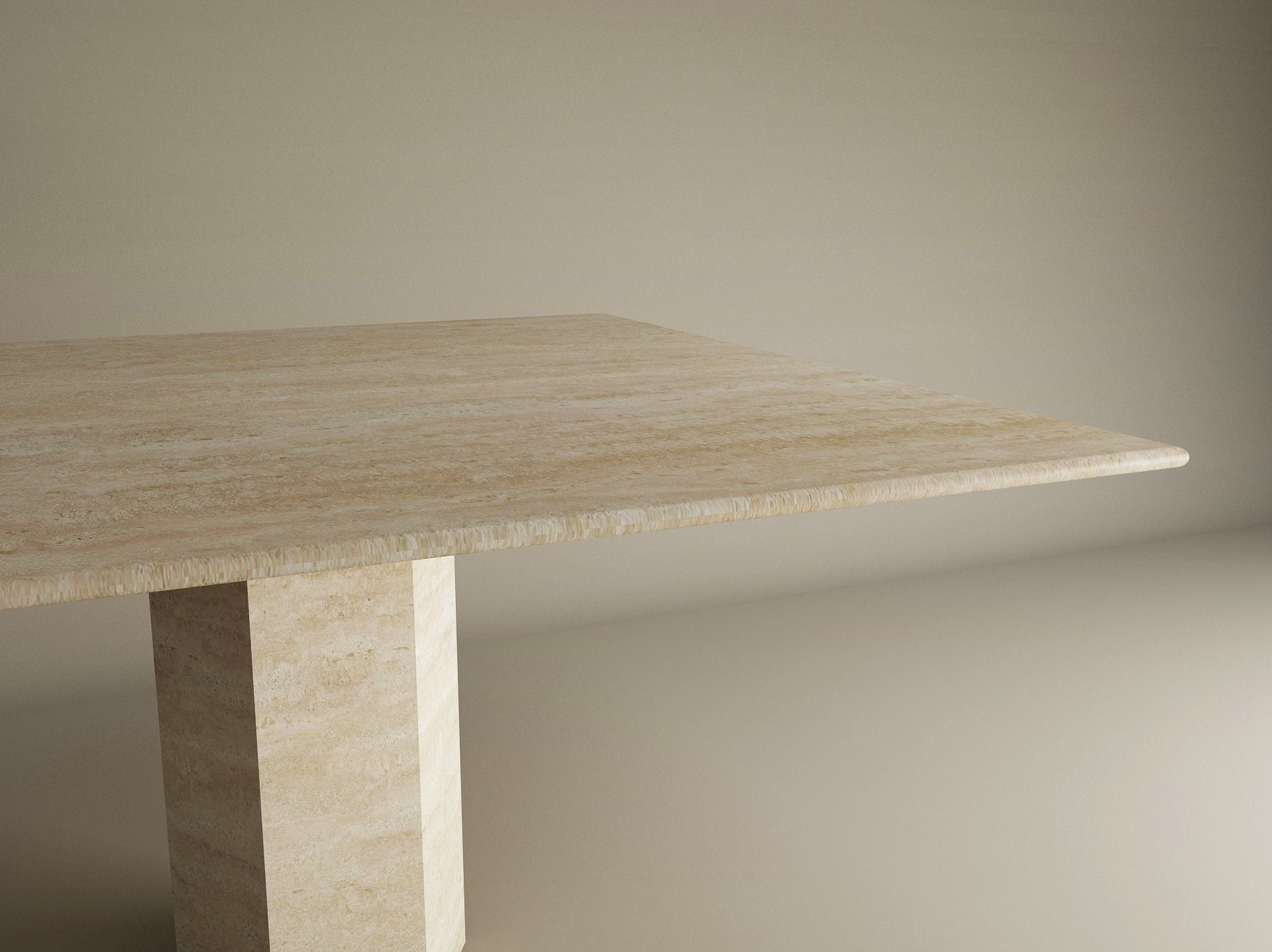 A partial view of the TRAVERTABLE Square Travertine Dining Table with Hexagonal Center Base is shown against a plain, light background, highlighting its beige stone top and geometric pedestal.