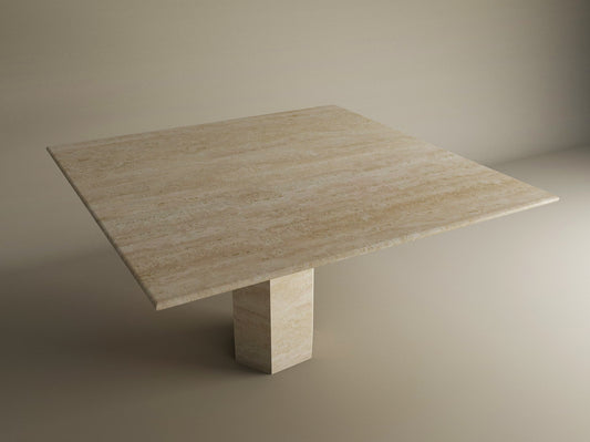 The TRAVERTABLE Square Travertine Dining Table features a light beige natural stone top and a bold hexagonal center base, blending geometric style with customization options, shown against a neutral backdrop.