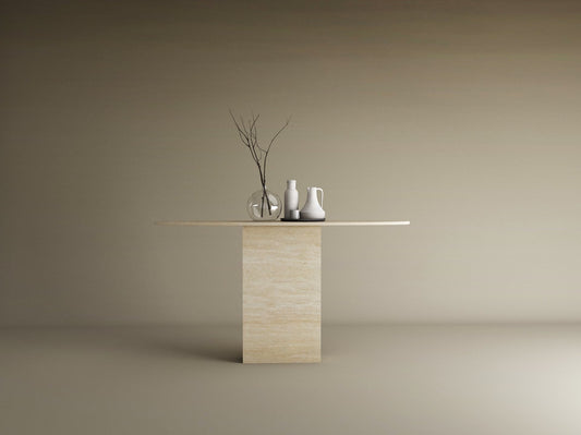 The TRAVERTABLE Ellips Travertine Console Table with Block Base showcases natural stone elegance, adorned with two white vases, a clear vase, and bare branches, all set against a plain light brown background.