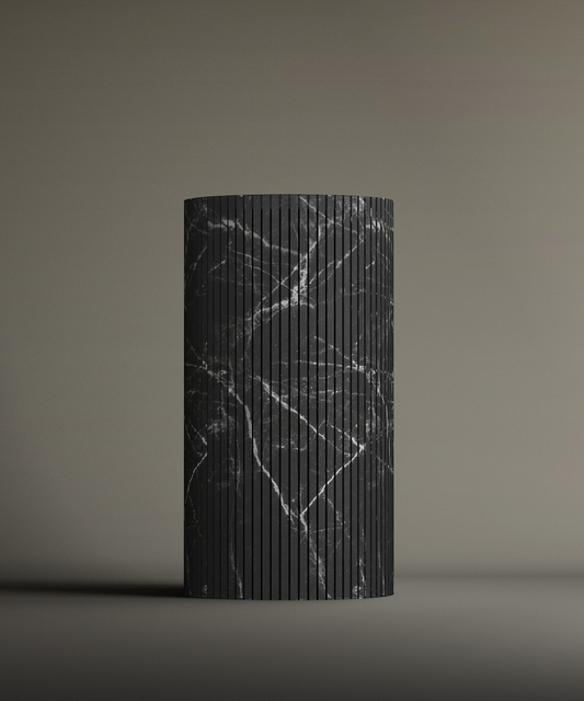 The TRAVERTABLE Nero Marquina Round Fluted Marble Pedestal Vanity Sink features a tall, cylindrical shape with white-veined black marble and fluted grooves, elegantly displayed on a plain gradient background.