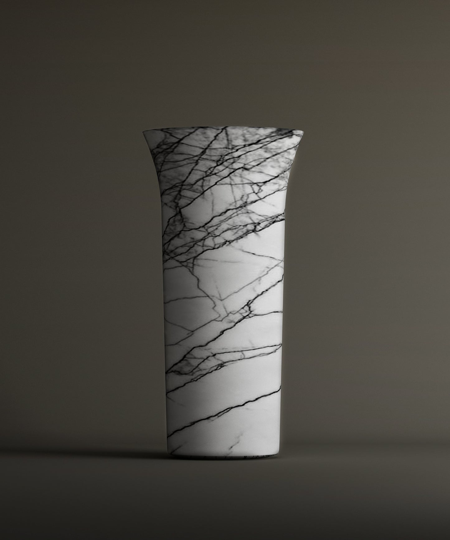 The TRAVERTABLE Lilac Marble Cylinder Pedestal Vanity Sink showcases striking black veining on white marble with a flared rim, set against a plain brownish-gray background.